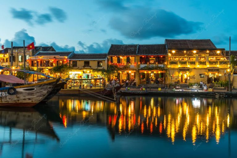 Fishing boat restaurants and illuminated restaurant buildings reflecting in the Thu Bon River at Hoi Ann Old Town riverfront, Vietnam