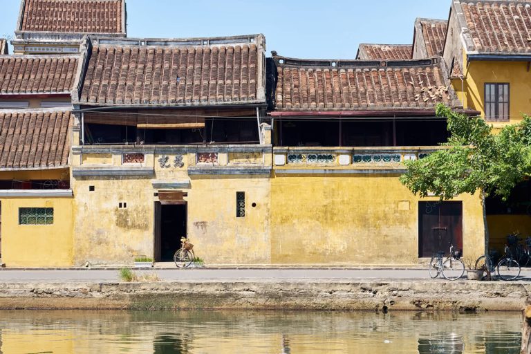 Classic yellow pastel coloured house with weathered walls at Hoi Ann Old Town riverfront, Vietnam