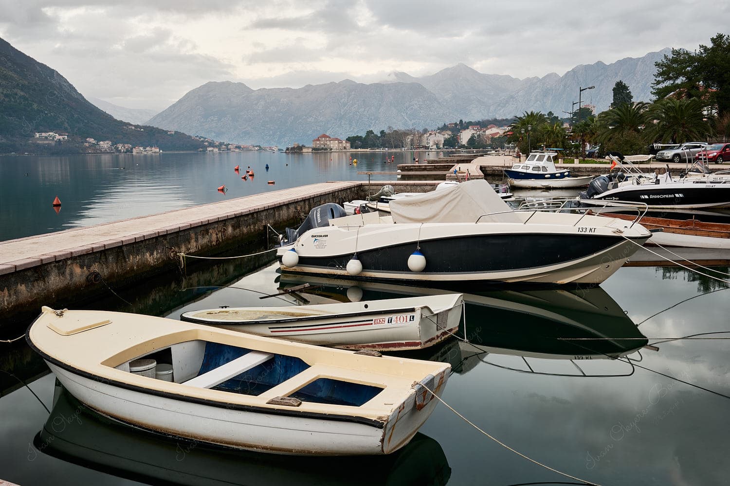 Promenade view of boats at Kotor Bay and mountains, Kotor, Montenegro Promenade view of boats at Kotor Bay and mountains, Kotor, Montenegro