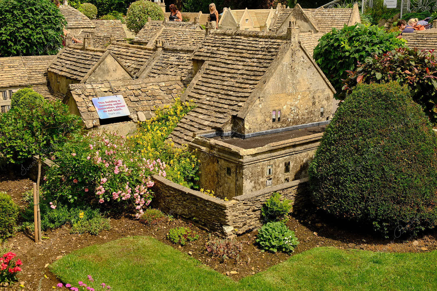 Elevated standing view of miniature replica traditional English stone cottages and garden in Bourton on the Water Model Village, England, UK