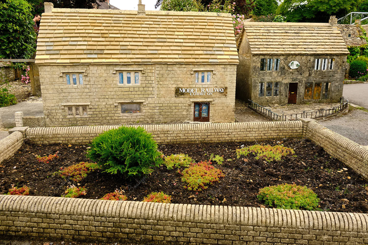 Elevated standing view of miniature replica traditional English stone houses in Bourton on the Water Model Village, England, UK