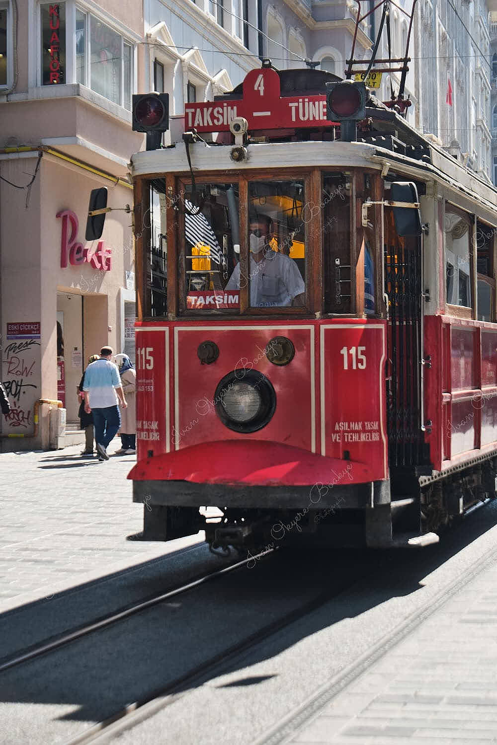 Turkish heritage tram driver wearing a face mask driving a tram through İstiklal Caddesi, Istanbul, Turkey