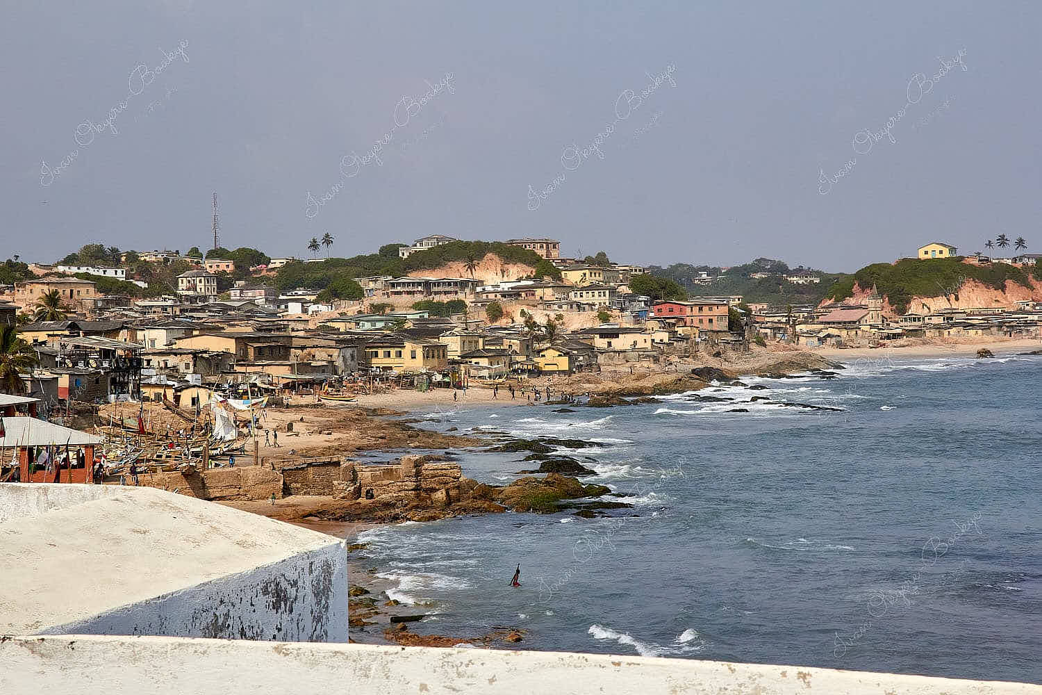 View of weathered pastel coloured houses lining the shore at Cape Coast, Ghana