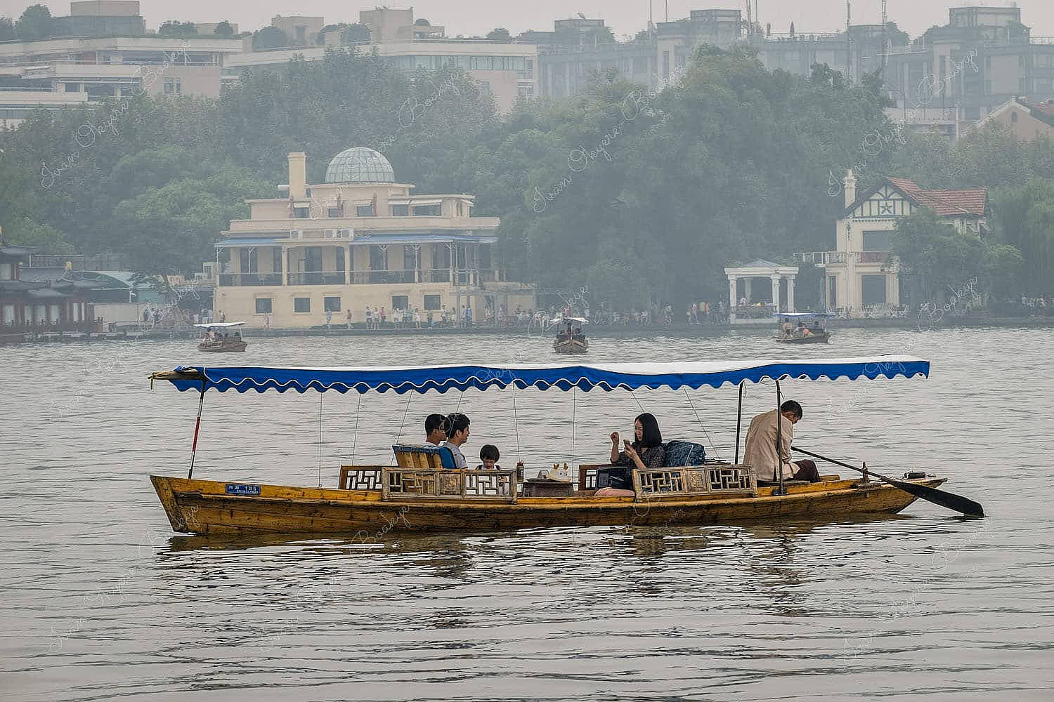 Family in row boat in West Lake, Hangzhou, China
