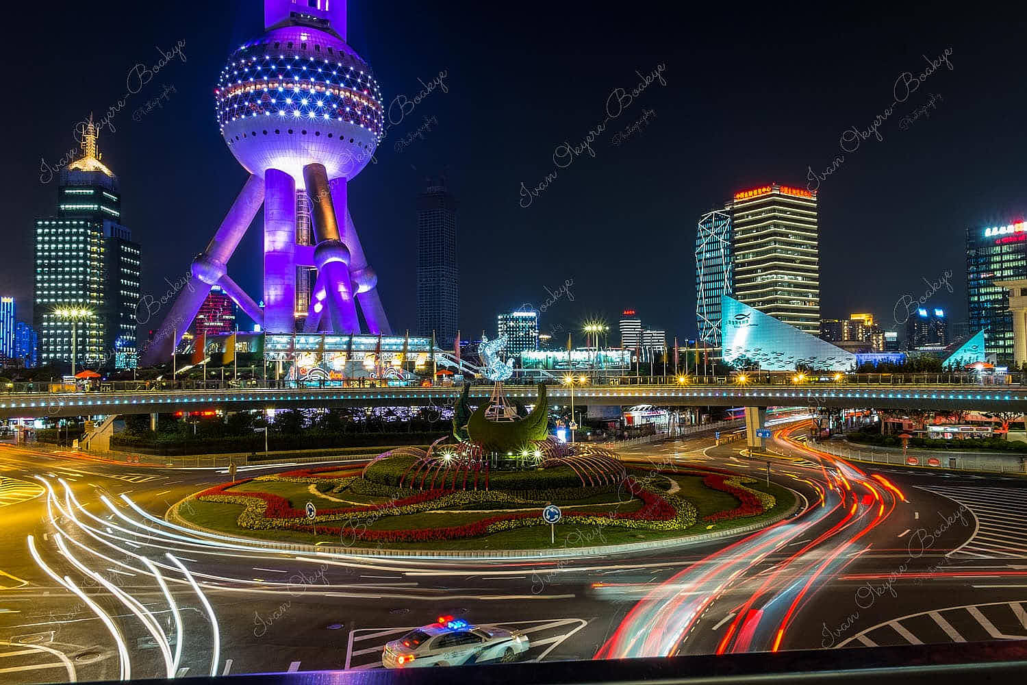 Light trails at night at roundabout with The Oriental Pearl TV Tower in the background, Shanghai, China