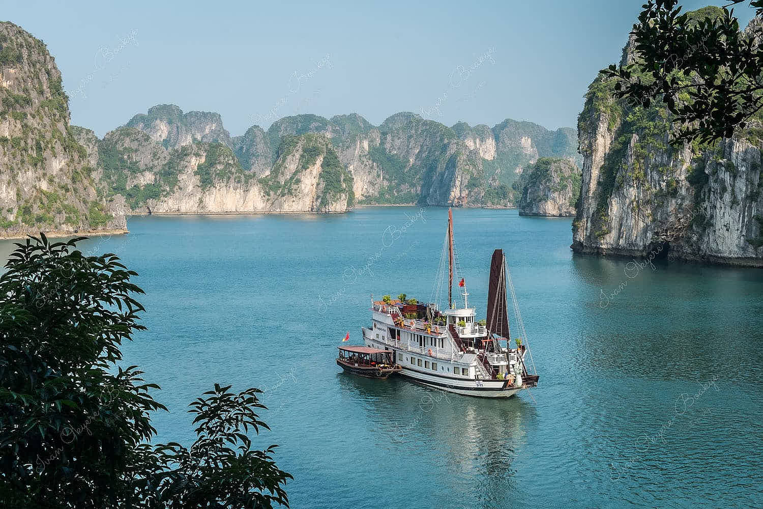 Junk boat surrounded by karst mountains in Halong Bay, Vietnam