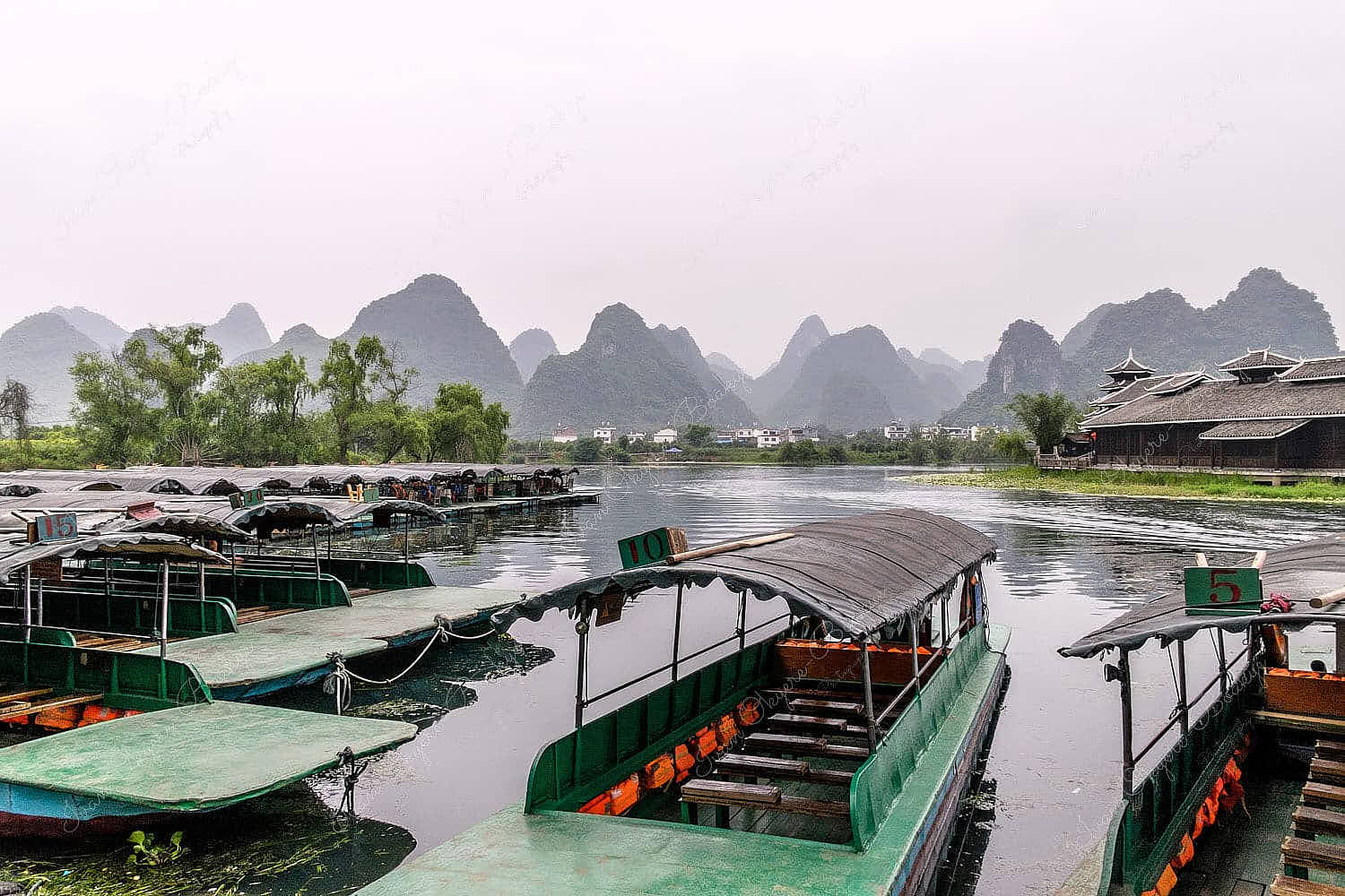 Moored cruise boats on Swallow Lake with majestic karst mountains in the background in Shangri-la Park, Guilin, China