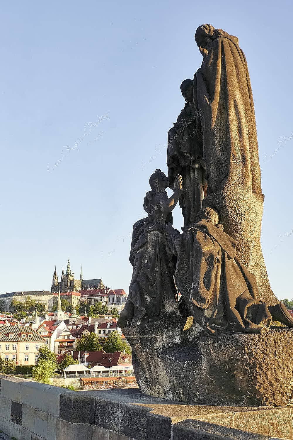 The statues of St. Cyril and St. Methodius on Charles Bridge with Prague Castle and St. Vitus Cathedral in the background, Prague, Czech Republic