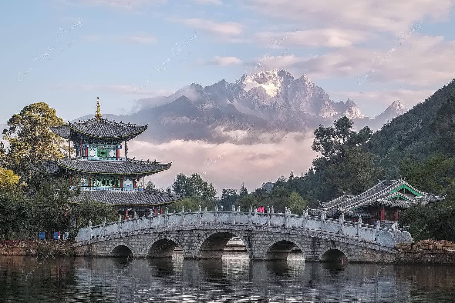 The Moon Embracing Pavilion, Suocui Bridge and Black Dragon Pool against the backdrop of the Jade Dragon Snow Mountain in Lijiang, China