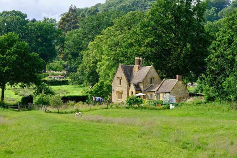 Stone house and sheep in Moreton-in-Marsh countryside, Cotswolds, UK